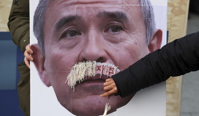 In this Dec. 13, 2019, photo, a protester plucks face mustache from a picture of U.S. Ambassador to South Korea Harry Harris during a rally to denounce the United States&#x27; policies against North Korea near the U.S. Embassy in Seoul, South Korea. Harris has some unusual explanations for the harsh criticism he&#x27;s faced in his host country. His mustache, maybe? Or a Japanese ancestry that raises unpleasant reminders of Japan&#x27;s former colonial domination of Korea? (Lee Yong-hwan/Newsis via AP) ** FILE **