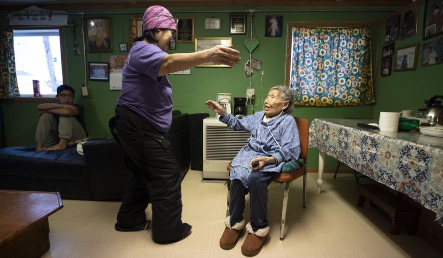 In this Monday, Jan. 20, 2020 image, Lizzie Chimiugak, right, gets a hug from her granddaughter Janet Lawrence at her home in Toksook Bay, Alaska. Chimiugak, who turned 90 years old on Monday, is scheduled to be the first person counted in the 2020 U.S. Census on Tuesday. (AP Photo/Gregory Bull)