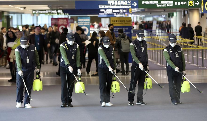 Workers spray antiseptic solution on the arrival lobby amid rising public concerns over the possible spread of a new coronavirus at Incheon International Airport in Incheon, South Korea, Tuesday, Jan. 21, 2020. Heightened precautions were being taken in China and elsewhere Tuesday as governments strove to control the outbreak of a novel coronavirus that threatens to grow during the Lunar New Year travel rush. (Suh Myung-geon/Yonhap via AP)