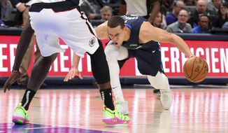 Dallas Mavericks forward Dwight Powell (7) stumbles due to injury in the first half of an NBA basketball game against the Los Angeles Clippers Tuesday, Jan. 21, 2020 in Dallas. (AP Photo/Richard W. Rodriguez)