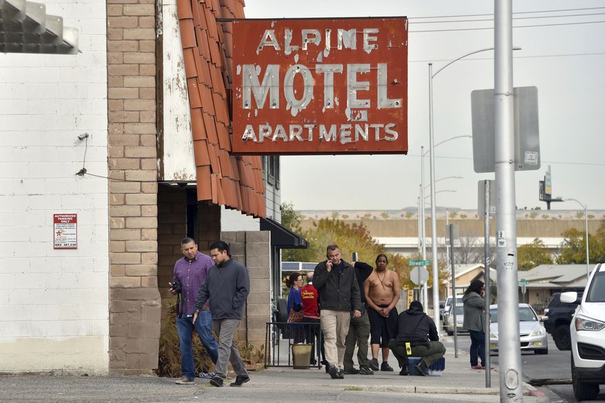 FILE - In this Dec. 21, 2019, file photo, investigators work the scene of a fire at the three-story Alpine Motel Apartments in Las Vegas. Search warrant records show that investigators seized a computer and paperwork on Jan. 14, 2020, from the manager's office of the downtown Las Vegas apartment building where inspectors cited owners for code violations following a fire that killed six people and injured 13. No criminal charges have been filed in the ongoing probe of the deadly fire. (AP Photo/David Becker, File)