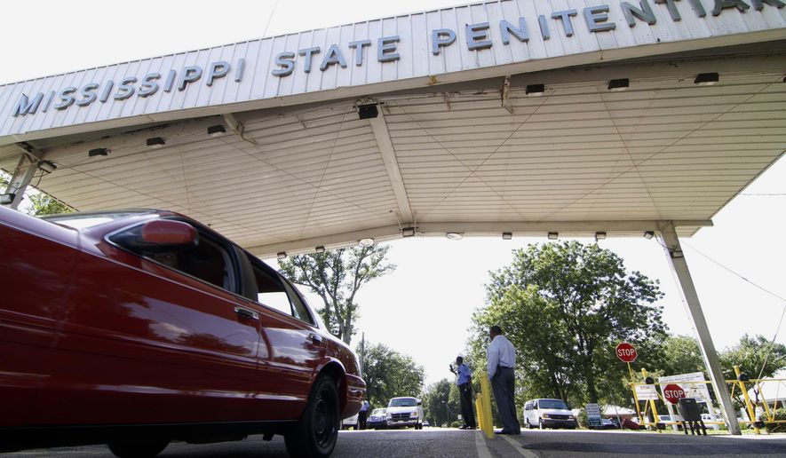 FILE - In this July 21, 2010, photo, employees leave the front gate of the Mississippi State Penitentiary in Parchman, Miss. An inmate at the Mississippi prison that was a focus of recent deadly unrest was found hanging in his cell by two corrections officers over the weekend and pronounced dead, a coroner said Sunday, Jan. 19, 2020. (AP Photo/Rogelio V. Solis, File)