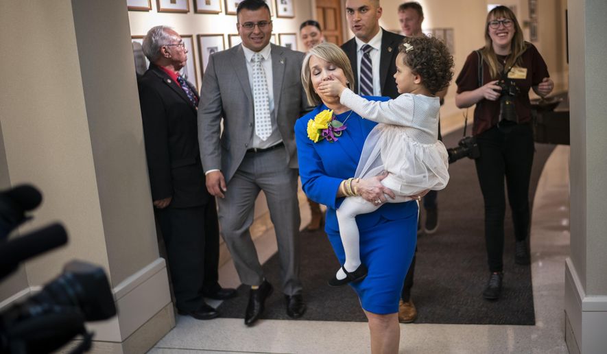 New Mexico Gov. Michelle Lujan Grisham is silenced by her granddaughter Avery Stewart while being escorted out following the State of the State address opening the New Mexico legislative session in the house chambers at the state Capitol in Santa Fe, N.M. on Tuesday, Jan. 21, 2020. (AP Photo/Craig Fritz)