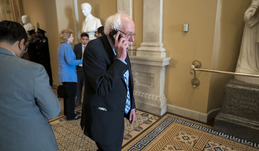 Democratic presidential candidate, Sen. Bernie Sanders, I-Vt., makes a phone call during a break as the Senate continues with the impeachment trial of President Donald Trump on charges of abuse of power and obstruction of Congress, at the Capitol in Washington, Wednesday, Jan. 22, 2020. (AP Photo/J. Scott Applewhite)