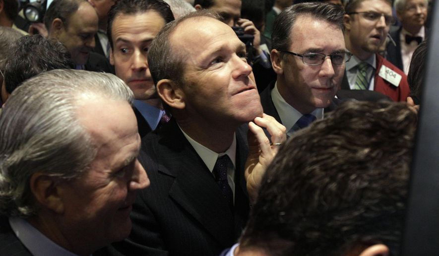 FILE - In this Jan. 26, 2011 file photo, Nielsen Company CEO David Calhoun, center, watches progress as he waits for the company&#39;s IPO to begin trading, on the floor of the New York Stock Exchange. Calhoun, Boeing&#39;s new CEO, said Wednesday, Jan. 22, 2020, that production of the 737 Max will resume this spring, months before the company expects federal regulators to certify the grounded plane to fly again. (AP Photo/Richard Drew, File)