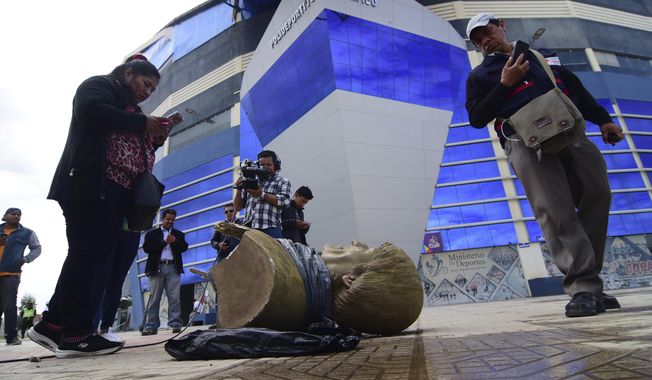 In this Jan. 13, 2020 photo, members of the media take images of a destroyed bust of Bolivia&#x27;s former President Evo Morales, after it was knocked down on the orders of Bolivia&#x27;s sports minister, outside a sports center in Cochabamba, Bolivia. Across Bolivia, the government of interim President Jeanine Áñez is taking down statues, painting over murals, changing the names of soccer fields and stadiums, and trying to erase the legacy of the former leader, who ruled the Andean country for more than 14 years as its first indigenous president. (Daniel James/Los Tiempos via AP)
