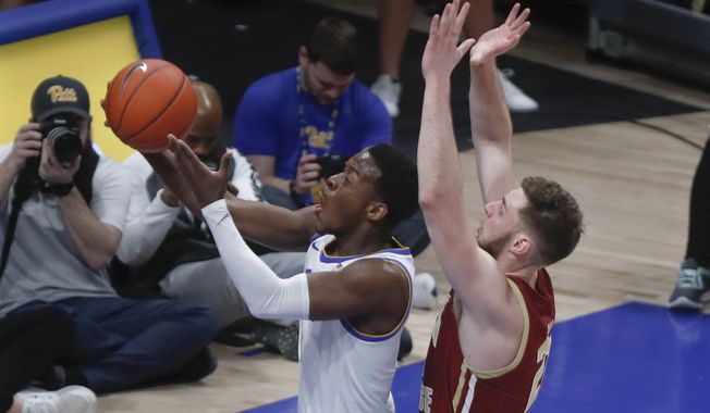 Pittsburgh&#x27;s Xavier Johnson, left, shoots as Boston College&#x27;s Nik Popovic defends during the first half of an NCAA college basketball game, Wednesday, Jan. 22, 2020, in Pittsburgh. (AP Photo/Keith Srakocic)