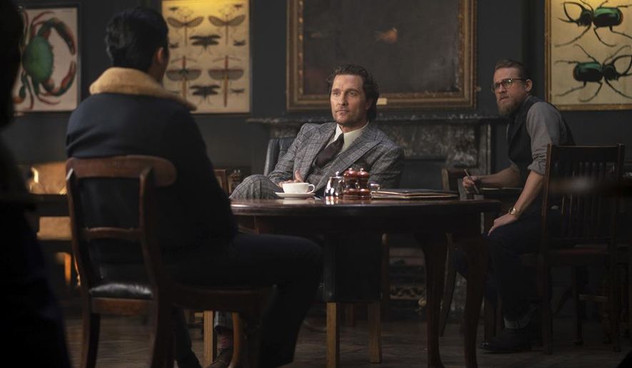 This image released by STXfilms shows, from left, Henry Golding, Matthew McConaughey and Charlie Hunnam in a scene from "The Gentlemen." (Christopher Raphael/STXfilms via AP)