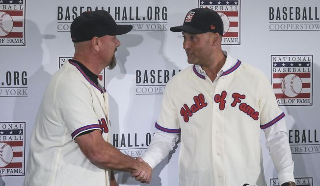 Colorado Rockies outfielder Larry Walker, left, and New York Yankees shortstop Derek Jeter shake hands after receiving their Baseball Hall of Fame jersey and cap, Wednesday Jan. 22, 2020, during a news conference in New York. (AP Photo/Bebeto Matthews)