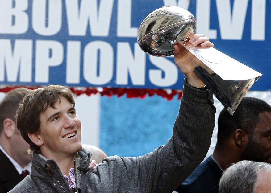 In this Feb. 7, 2012 file photo New York Giants quarterback Eli Manning holds up the Vince Lombardi Trophy during the team&#39;s NFL football Super Bowl parade in New York. Manning, who led the Giants to two Super Bowls in a 16-year career that saw him set almost every team passing record, has retired. The Giants said Wednesday, Jan. 22, 2020 that Manning would formally announce his retirement on Friday. (AP Photo/Julio Cortez, file)