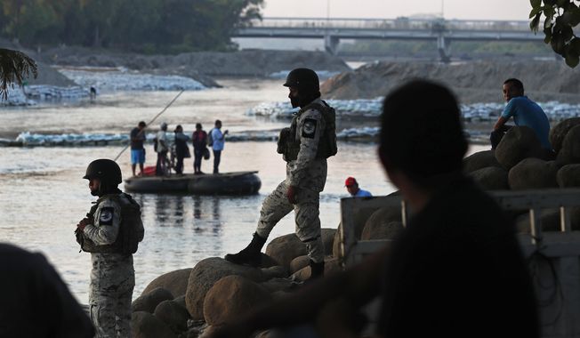 Mexican National Guards stand watch over the the Suchiate River where locals transport food and people between Mexico and Guatemala, as they stand near Ciudad Hidalgo, Mexico, Wednesday, Jan. 22, 2020, a location popular for migrants to cross from Guatemala to Mexico. Mexico announced last June that it was deploying the newly formed National Guard to assist in immigration enforcement to avoid tariffs that Trump threatened on Mexican imports. (AP Photo/Marco Ugarte)