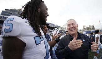 North Carolina head coach Mack Brown, right, reacts with offensive lineman Joshua Ezeudu, left, after Brown was doused with water during the second half of the Military Bowl NCAA college football game against Temple, Friday, Dec. 27, 2019, in Annapolis, Md. North Carolina won 55-13. (AP Photo/Julio Cortez)