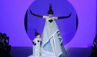 FILE - In this Wednesday, Jan. 24, 2018 file photo, Model Coco Rocha, right, poses with her 2-year-old daughter Ioni Conran wearing creations for the Jean Paul Gaultier Haute Couture Spring-Summer 2018 fashion collection presented in Paris. Fashion icon Jean Paul Gaultier has announced his retirement from couture catwalk collections - the designer’s only remaining runway shoe since putting an end to his ready-to-wear collections in 2014. In a tweet, the ever-smiling and flamboyant 67-year-old said the couture show on Wednesday, Jan. 22, 2020 “celebrating 50 years of my career will also be my last.” He added: “But rest assured, haute couture will continue with a new concept.” (AP Photo/Francois Mori, file)