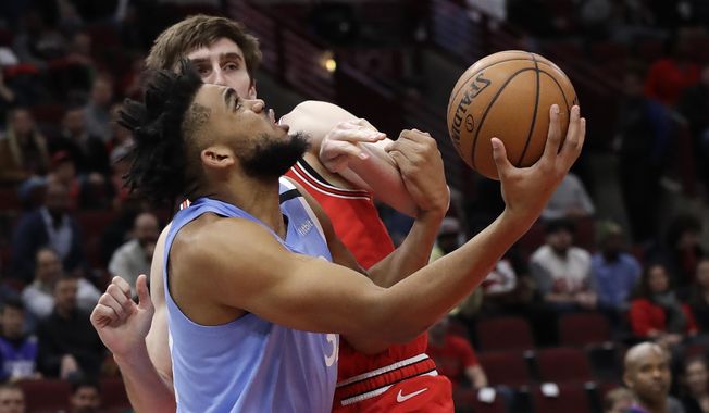 Minnesota Timberwolves center Karl-Anthony Towns, front, shoots against Chicago Bulls forward Luke Kornet during the first half of an NBA basketball game in Chicago, Wednesday, Jan. 22, 2020. (AP Photo/Nam Y. Huh)