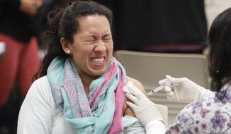 Ana Farfan reacts to getting an influenza vaccine shot at Eastfield College in Mesquite, Texas, Thursday, Jan. 23, 2020. According to the Dallas County Health and Human Services Department, who offered the free flu vaccinations, Dallas County reported its 11th-flu related death of the 2019-2020 season on Wednesday. This flu season started early and all but two states reported widespread outbreaks by the week ended Jan. 11, according to the U.S. Centers for Disease Control and Prevention. (AP Photo/LM Otero)