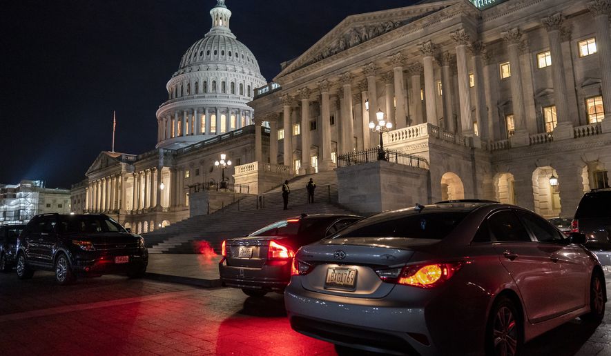Official&#39;s vehicles wait outside the Senate as lawmakers work late Thursday, Jan. 23, 2020, on arguments in the impeachment trial of President Donald Trump on charges of abuse of power and obstruction of Congress, in Washington. (AP Photo/J. Scott Applewhite)