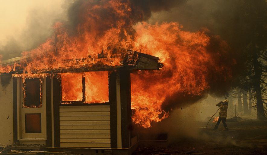 A firefighter battles the Morton Fire as it consumes a home near Bundanoon, New South Wales, Australia, Thursday, Jan. 23, 2020. (AP Photo (AP Photo/Noah Berger)