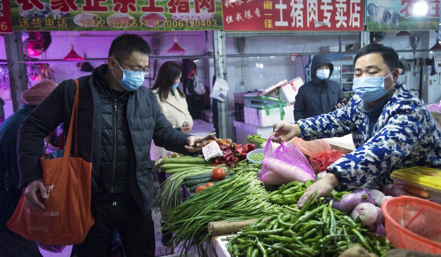 In this photo released by China&#x27;s Xinhua News Agency, people shop for vegetables at a market in Wuhan in central China&#x27;s Hubei Province, early Thursday, Jan. 23, 2020. China closed off a city of more than 11 million people Thursday in an unprecedented effort to try to contain a deadly new viral illness that has sickened hundreds and spread to other cities and countries in the Lunar New Year travel rush. (Xiao Yijiu/Xinhua via AP)