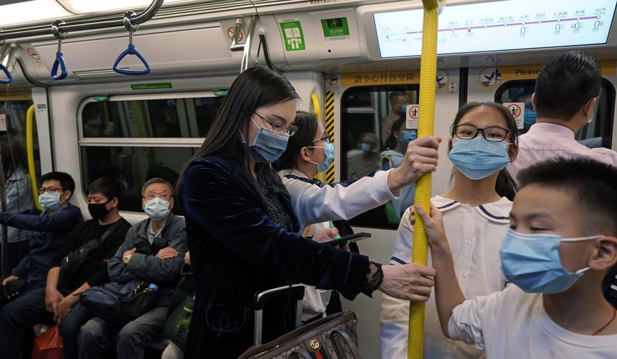 Passengers wear protective face masks on the subway in Hong Kong, Thursday, Jan. 23, 2020. China closed off a city of more than 11 million people Thursday, halting transportation and warning against public gatherings, to try to stop the spread of a deadly new virus that has sickened hundreds and spread to other cities and countries in the Lunar New Year travel rush. (AP Photo/Kin Cheung)