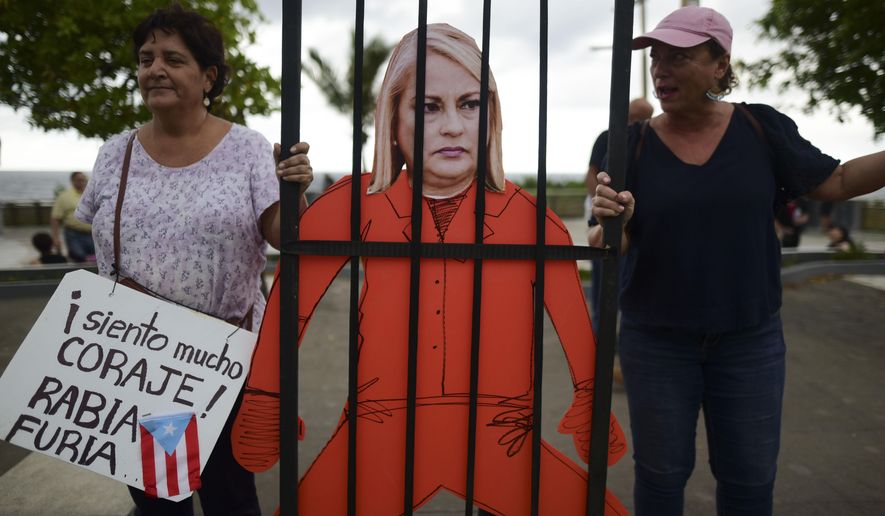 Protesters hold an image of Gov. Wanda Vázquez during a protest organized by Puerto Rican singer Rene Perez of Calle 13 over emergency aid that until recently sat unused in a warehouse amid ongoing earthquakes, in San Juan, Puerto Rico, Thursday, Jan. 23, 2020. Protesters are demanding Vázquez&#x27;s ouster. (AP Photo/Carlos Giusti)