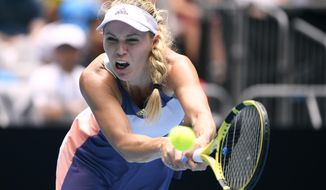 Denmark&#39;s Caroline Wozniacki makes a backhand return to Tunisia&#39;s Ons Jabeur in their third round singles match at the Australian Open tennis championship in Melbourne, Australia, Friday, Jan. 24, 2020. (AP Photo/Andy Brownbill)