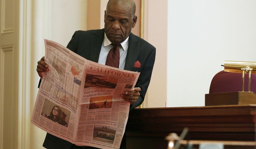 FILE - In this Aug. 16, 2018 file photo, state Sen. Steven Bradford, D-Gardena, looks over a newspaper during a break in the Senate session, in Sacramento, Calif. Sen. Patricia Bates, R-Laguna Niguel, announced Thursday, Jan. 23, 2020 that she has introduced legislation exempting freelance writers and newspaper carriers from a broad new California law requiring that many be treated as employees rather than independent contractors. (AP Photo/Rich Pedroncelli, File)