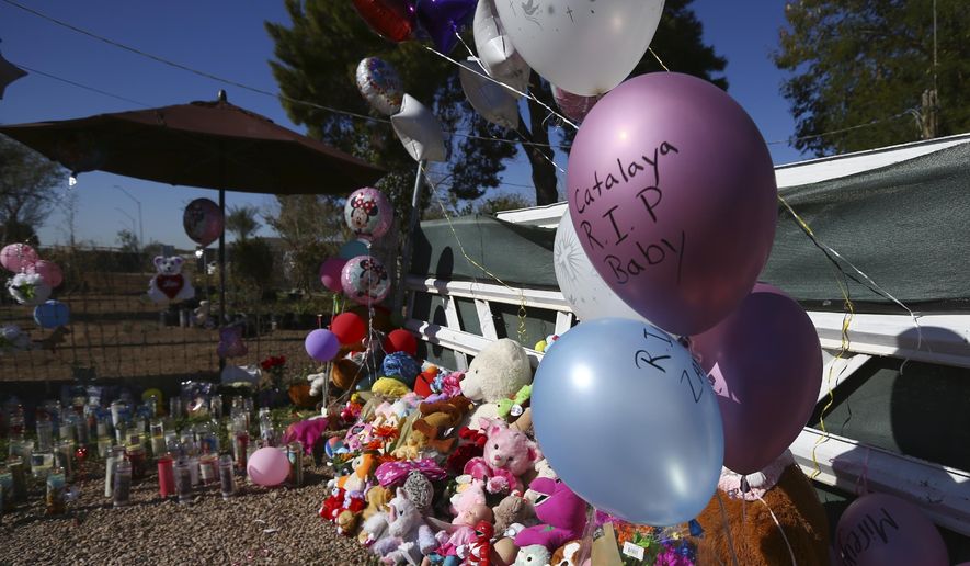 A makeshift memorial grows in front of the home where Rachel Henry was arrested on suspicion of killing her three children after they were found dead inside the family home earlier in the week, shown here Thursday, Jan. 23, 2020, in Phoenix. (AP Photo/Ross D. Franklin)