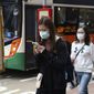 People wear protective face masks on a street in Hong Kong, Friday, Jan 24, 2020. China closed off a city of more than 11 million people Thursday, halting transportation and warning against public gatherings, to try to stop the spread of a deadly new virus that has sickened hundreds and spread to other cities and countries in the Lunar New Year travel rush. (AP Photo/Achmad Ibrahim)