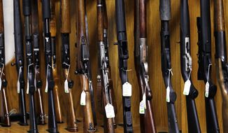 In this Oct. 20, 2017, file photo, rifles are lined up and ready to be auctioned at Johnny&#x27;s Auction House, where the company handles gun sales for about a half dozen police departments and the Lewis County Sheriff&#x27;s Office, in Rochester, Wash. (AP Photo/Elaine Thompson, File)