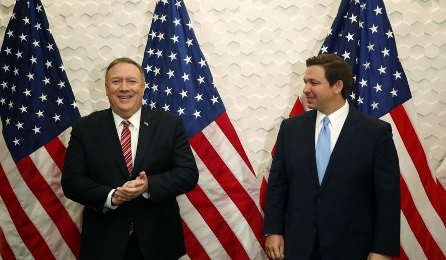 Secretary of State Mike Pompeo, left, and Florida Gov. Ron DeSantis pose for a photo before participating in a roundtable discussion with Venezuelan exiles, Thursday, Jan. 23, 2020, in Miami. (AP Photo/Wilfredo Lee)
