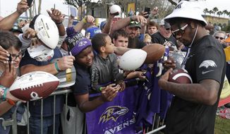 AFC quarterback Lamar Jackson, of the Baltimore Ravens, signs autographs during a practice for the NFL Pro Bowl football game Thursday, Jan. 23, 2020, in Kissimmee, Fla. (AP Photo/John Raoux)