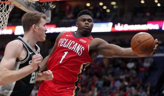 New Orleans Pelicans forward Zion Williamson (1) pulls in a rebound against San Antonio Spurs center Jakob Poeltl (25) in the second half of an NBA basketball game in New Orleans, Wednesday, Jan. 22, 2020. The Spurs won 121-117. (AP Photo/Gerald Herbert) ** FILE **