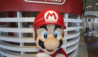 FILE - In this July 30, 2019, file photo, a Super Mario figure is displayed at a showroom in Tokyo. After months of being tight-lipped, Comcast executives on Thursday, Jan. 23, 2020, said the fourth park at Universal Orlando would be based on characters from Nintendo. (AP Photo/Koji Sasahara, File)