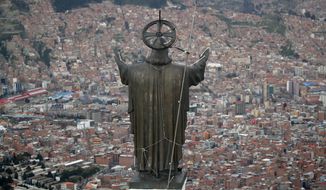 In this picture taken Tuesday, Jan. 7, 2020, a Christ statue overlooks El Alto, a city adjoining the capital city La Paz, Bolivia. Ancestral indigenous practices became more visible during the presidency of Evo Morales, who recognized the Andean earth deity Pachamama. While Bolivians are divided on former President Morales&#39; legacy, the interim President Jeanine Añez wants to make the Bible front and center in public life. (AP Photo/Natacha Pisarenko)