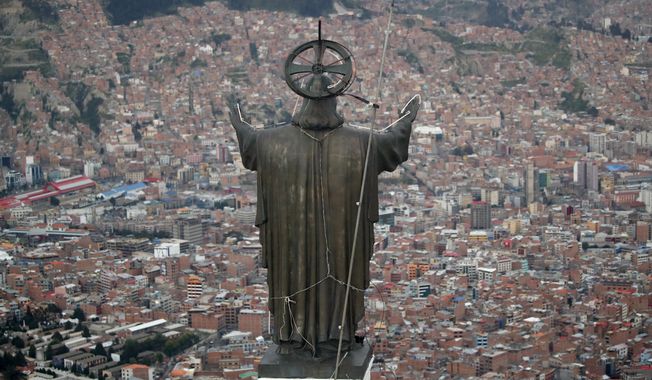 In this picture taken Tuesday, Jan. 7, 2020, a Christ statue overlooks El Alto, a city adjoining the capital city La Paz, Bolivia. Ancestral indigenous practices became more visible during the presidency of Evo Morales, who recognized the Andean earth deity Pachamama. While Bolivians are divided on former President Morales&#x27; legacy, the interim President Jeanine Añez wants to make the Bible front and center in public life. (AP Photo/Natacha Pisarenko)
