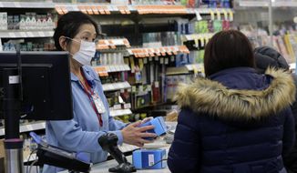 A sales clerk at a pharmacy rings up a purchase of face masks as fears of the coronavirus continues Friday, Jan 24, 2020, in Chicago. A Chicago woman has become the second U.S. patient diagnosed with the dangerous new virus from China, health officials announced Friday. (Antonio Perez/Chicago Tribune via AP) **FILE**