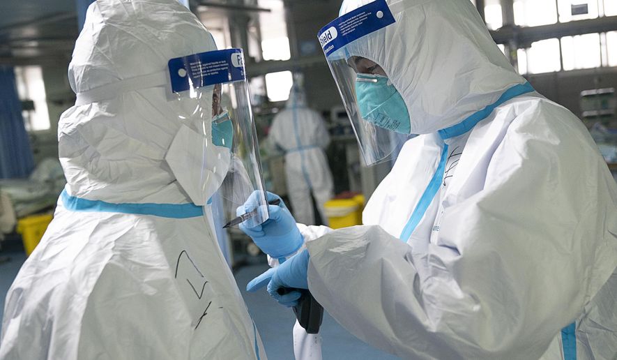 In this photo released by China&#39;s Xinhua News Agency, a medical worker writes their colleague&#39;s name on a protective suit to aid in identification as they work at Zhongnan Hospital of Wuhan University in Wuhan in central China&#39;s Hubei Province, Firday, Jan. 24, 2020. China announced Friday that it is swiftly building a 1,000-bed hospital dedicated to patients infected with a new virus that has killed 26 people, sickened hundreds and prompted unprecedented lockdowns of cities during the country&#39;s most important holiday. (Xiong Qi/Xinhua via AP)