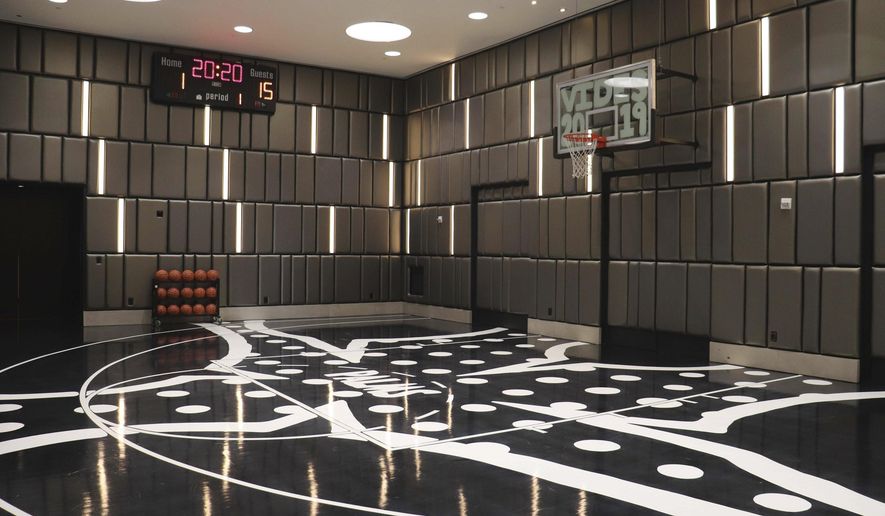 This undated photo shows the regulation-sized half basketball court at the $20,000-per-night Hardwood Suite at The Palms hotel-casino in Las Vegas. The two-story suite also includes a hidden whiskey room, a game room with pool and poker tables, multiple big-screen TVs, a fully-stocked 16-seat bar and a dining table for 10 guests. On this court, the butler keeps score. (Ed Komenda/The Reno Gazette-Journal via AP)