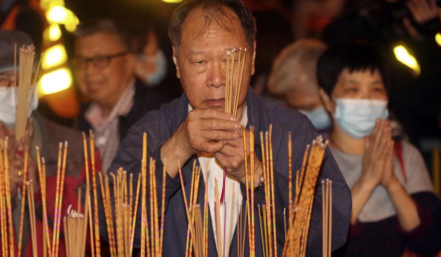 A man burn joss sticks as he prays at the Wong Tai Sin Temple, Friday, Jan. 24, 2020, in Hong Kong, to celebrate the Lunar New Year which marks the Year of the Rat in the Chinese zodiac. China is expanding its lockdown against the deadly new virus to an unprecedented 36 million people and rushing to build a prefabricated, 1,000-bed hospital for victims as the outbreak cast a pall over Lunar New Year, the country’s biggest and most festive holiday. (AP Photo/Achmad Ibrahim)