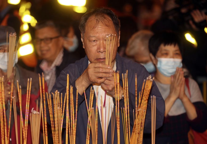 A man burn joss sticks as he prays at the Wong Tai Sin Temple, Friday, Jan. 24, 2020, in Hong Kong, to celebrate the Lunar New Year which marks the Year of the Rat in the Chinese zodiac. China is expanding its lockdown against the deadly new virus to an unprecedented 36 million people and rushing to build a prefabricated, 1,000-bed hospital for victims as the outbreak cast a pall over Lunar New Year, the country’s biggest and most festive holiday. (AP Photo/Achmad Ibrahim)