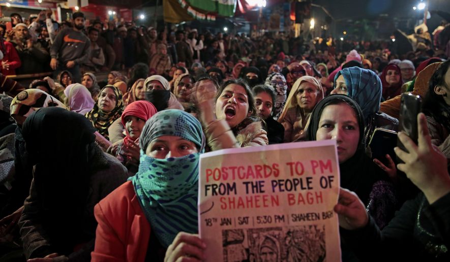 In this Saturday, Jan. 18, 2020 photo, women protesters shout slogans at the protest site at Shaheen Bagh area in New Delhi, India. Muslim women are transcending the confines of their homes to lay claim to the streets of this nondescript Muslim neighborhood in the Indian capital and slowly transforming it into a nerve center of resistance against a new citizenship law that has unleashed protests across the country. The women, sitting in the middle of a major highway, have taken turns maintaining an around the clock sit-in for more than a month. They sing songs of protest and chant anti-government slogans, some cradling babies, others laying down rugs to make space for more people to sit. (AP Photo/Altaf Qadri)