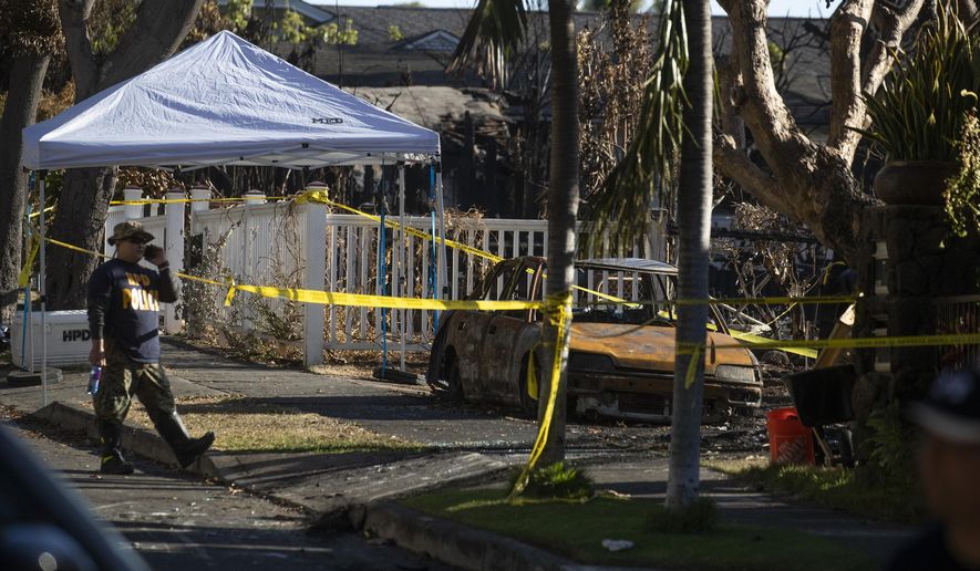 A Hawaii police officer stands in the neighborhood where fire destroyed several homes after a shooting in Honolulu over the weekend, Wednesday, Jan. 22, 2020. Hawaii has some of the nation&#x27;s strictest gun laws, but the killing of two Honolulu police officers by a man believed to have psychiatric issues has given new urgency to efforts to close gun control loopholes and bolster mental health treatment.  (Cindy Ellen Russell/Honolulu Star-Advertiser via AP)