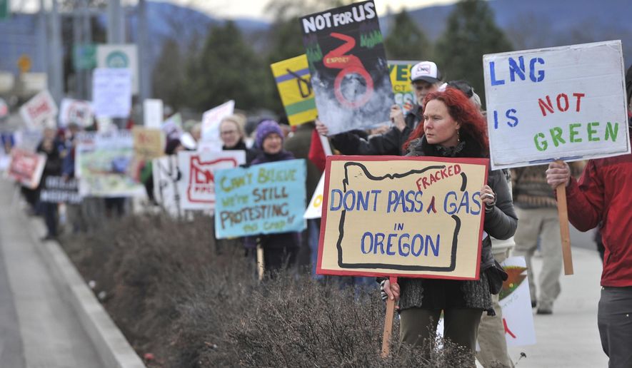 FILE - In this Jan. 6, 2016, file photo, people protest against the Jordan Cove LNG Pipeline on Crater Lake Highway in Medford, Ore. A Canadian energy company on Friday, Jan. 24, 2020, withdrew its application for a state permit for the project, and a project spokesman said it is instead awaiting possible federal approval. (Jamie Lusch/The Medford Mail Tribune via AP, File)