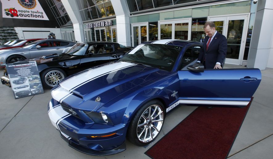 File - In this Oct. 23, 2019, file photo, McGregor Scott, the U.S. Attorney for the Eastern District of California, looks over a 2007 Ford Shelby GT500 displayed in Sacramento, Calif., that was among the vehicles seized by the federal government to be auctioned off. The cars belonged to owners of a San Francisco Bay Area solar energy company that have pleaded guilty for participating in what federal prosecutors called a massive Ponzi scheme that defrauded investors of $1 billion. Jeff and Paulette Carpoff entered pleas Friday, Jan. 24, 2020, involving the scam that could result in up to 30 years in prison for him, and up to 15 years in prison for her. (AP Photo/Rich Pedroncelli, File)