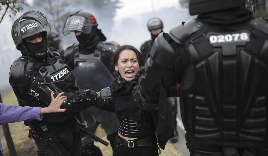 Police detain a protester in Bogota, Colombia, Tuesday, Jan. 21, 2020. Student and labor groups called for new protests as they hope to reignite demonstrations against President Ivan Duque that brought thousands to the streets late last year with a wide range of grievances with his conservative government. (AP Photo/Ivan Valencia)