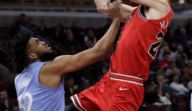Chicago Bulls forward Lauri Markkanen, right, drives to the basket against Minnesota Timberwolves center Karl-Anthony Towns during the second half of an NBA basketball game in Chicago, Wednesday, Jan. 22, 2020. The Bulls won 117-110.(AP Photo/Nam Y. Huh)