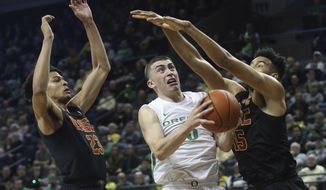 Oregon&#39;s Payton Pritchard, center, goes up for a shot between Southern California&#39;s Max Agbonkpolo, left, and Isaiah Mobley, right, during the first half of an NCAA basketball game in Eugene, Ore., Thursday, Jan. 23, 2020. (AP Photo/Chris Pietsch)