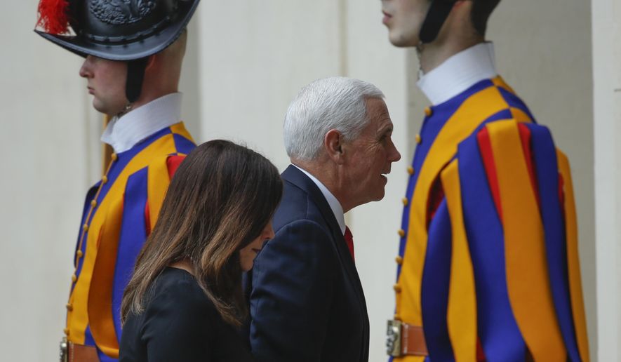 U.S. Vice President Mike Pence and his wife Karen walk past Vatican Swiss Guards as they arrive at the San Damaso courtyard at the Vatican ahead of their private audience with Pope Francis, Friday, Jan. 24, 2020. (AP Photo/Domenico Stinellis)