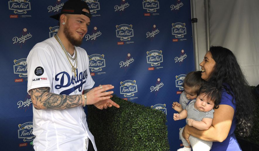 Los Angeles Dodgers&#39; Alex Verdugo, left, gets ready to have his picture taken with Desirae Cortez, right, along with her children Emma, second from left, and Julianna during Dodger Stadium FanFest Saturday, Jan. 25, 2020, in Los Angeles. (AP Photo/Mark J. Terrill)