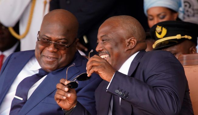 Congolese President Felix Tshisekedi, left, and outgoing president Joseph Kabila share a light moment side during the inauguration ceremony in Kinshasa, Democratic Republic of the Congo, Thursday Jan. 24, 2019. Tshisekedi won an election that raised numerous concerns about voting irregularities amongst observers as the country chose a successor to longtime President Kabila. (AP Photo/Jerome Delay)